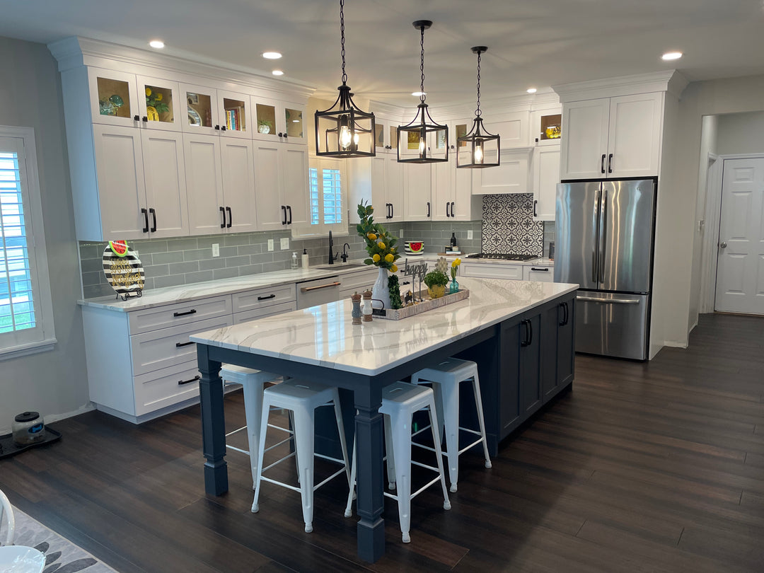 Custom cabinetry in a kitchen in st. louis, missouri. The cabinets are pure white and the island is hale navy, with glass uppers.