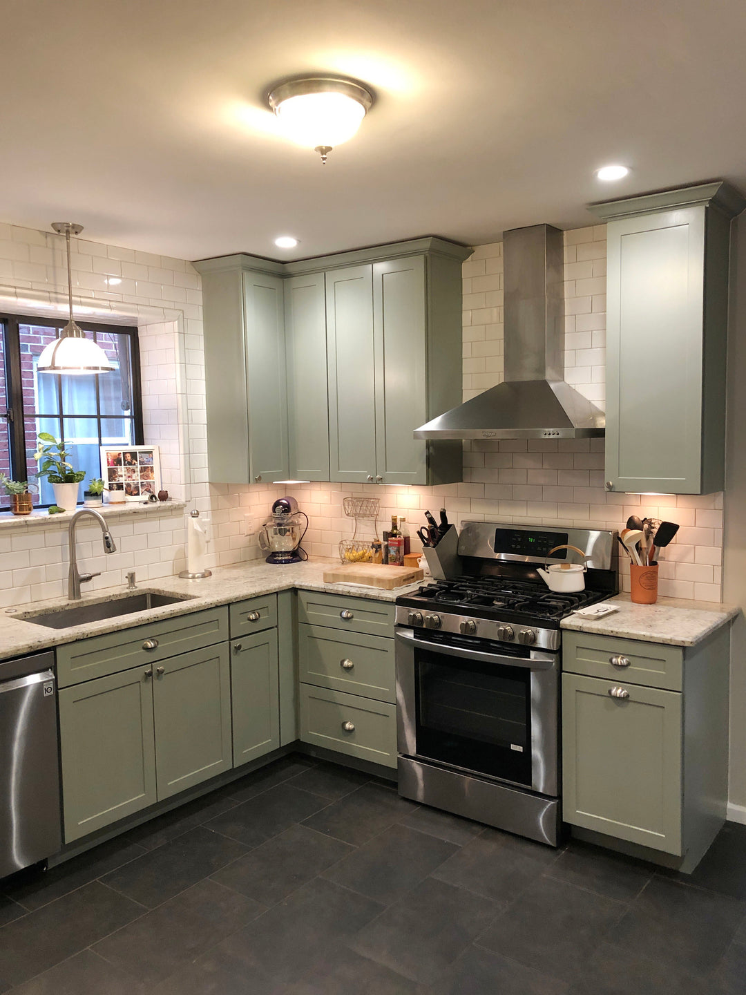 Beautifu pale green painted cabinets with white subway tile backsplash